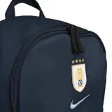 Mochila Nike AUF Heritage de color azul marino, con bolsillo frontal en celeste claro que incluye la inscripción 'Uruguay'. Presenta el escudo de la AUF con cuatro estrellas y el logo de Nike bordados en la parte superior.