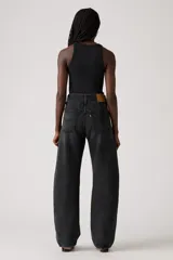 Pantalón de jean de corte baggy con diseño barrel, de tiro medio y color negro lavado. Presenta costuras laterales curvas que acentúan su silueta amplia y estructurada.