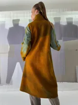 Tapado largo de fieltro de lana merino con teñido artesanal tie-dye en degradé de azul. Tiene cuello alto, cierre lateral con broches ocultos, bolsillos laterales y corte amplio.