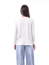 Remera de manga larga color crema con cuello redondo y un estampado central de un ramo de flores rosadas y naranjas en un jarrón azul oscuro.