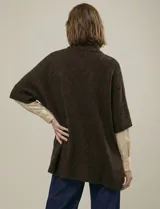 Capa tejida color fucsia, con cuello alto abotonado y mangas cortas estilo japonesa. Tejido de punto grueso.