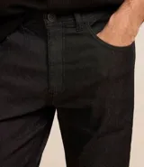 Pantalón de jean negro, modelo slim, con bolsillos laterales.
