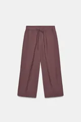 Pantalón color bordó, de tiro medio, con cintura elástica ajustable con cordones. Cuenta con bolsillos laterales ocultos en la costura y bolsillos de plastrón en la espalda.