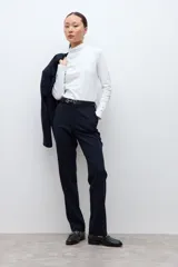 Pantalón de corte recto y estilo sastrero, confeccionado en tela de vestir color negro. Presenta cintura con trabillas para cinturón, cierre frontal con botón y bolsillos laterales.