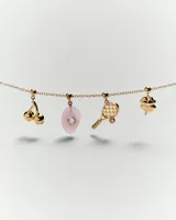 Aros colgantes con forma de cerezas doradas, con un pequeño cristal incrustado en una de ellas.