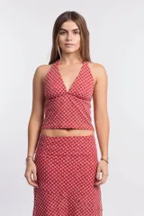 Pollera larga de tela liviana color rojo/rosado con estampado geométrico en blanco. Diseño asimétrico con corte irregular en el ruedo.