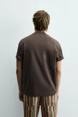 Camiseta de corte relajado confeccionada en tejido interlock de algodón con elasticidad, presenta cuello redondo y manga corta.