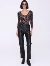 Body de tul con estampado animal print de cebra en tonos marrones y negros, con mangas largas y escote redondo.