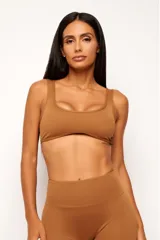 Top deportivo color tostado, con escote cuadrado y diseño ajustado. Incluye forro interno y apertura para almohadillas removibles.