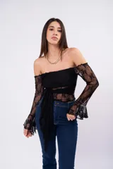 Blusa de encaje color bordó con diseño off-shoulder, mangas largas acampanadas y detalle de lazo frontal ajustable.