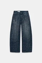 Jeans de tiro medio con corte baggy y cinco bolsillos. Presenta un diseño de estampado floral creado mediante la aplicación de strass a contraste sobre el denim. Cierre frontal con cremallera y botón metálico.