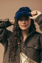 Gorro con visera de corderito color azul marino, de textura suave y abrigada.