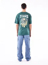 Remera negra de corte oversize con cuello redondo y manga corta. Presenta un pequeño estampado en el pecho con texto en color verde azulado.