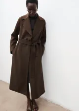 Abrigo largo de diseño recto confeccionado en tejido mezcla de lana. Presenta cuello con solapa, cierre frontal mediante cinturón tipo batín, manga larga y abertura posterior en el bajo.