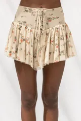 Minifalda con estampado floral, diseño de tiro alto con detalle de cordones frontales tipo corset y falda con volados.