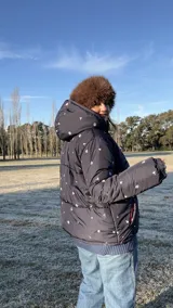 Campera puffer azul marino con estampado de motivos náuticos en blanco, rojo y verde.