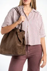 Camisa de corte oversize con estampado de rayas verticales, cuello clásico y mangas cortas. Presenta cierre frontal con botones y un diseño fluido y ligero.