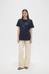 Remera de algodón color azul marino, con cuello redondo y diseño de flores bordadas con hilo fino en el frente.