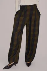 Pantalón de tiro alto con diseño fluido y estampado de cuadros en tonos oscuros. Presenta pliegues frontales, bolsillos delanteros con solapa y cierre frontal con cremallera, botón y ganchos metálicos.