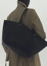 Bolso tipo shopper de efecto piel, con doble asa de hombro, cierre de botón magnético y bolsillo interior con cremallera.