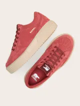 Championes Sorel modelo Ona Ave Low de gamuza rosada, con suela plataforma estriada color beige y el nombre de la marca impreso en dorado en el lateral.