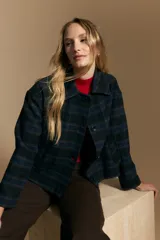 Tapado corto de lana con diseño a cuadros en tonos azul y negro, cuello camisero y cierre frontal con botones.