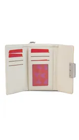 Billetera mediana de diseño bicolor, combinando una solapa en tono dorado metalizado con cuerpo en color negro. Presenta cierre perimetral, correa de muñeca extraíble con detalle de borla y placa metálica con logo de la marca en el frente.