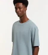 Remera de corte relajado y holgado, confeccionada en algodón de gramaje grueso con cuello redondo y mangas cortas.