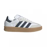 Championes adidas modelo Samba XLG, con diseño clásico de perfil bajo, parte superior de cuero blanco con detalles en denim oscuro en las icónicas tres tiras y el talón, puntera de gamuza gris y suela de goma color caramelo.