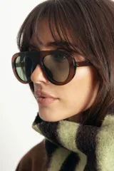Lentes de sol con armazón de policarbonato color marrón traslúcido y diseño envolvente de una sola pieza.