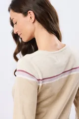 Buzo tejido de algodón con diseño a rayas en tonos beige, blanco y lila, de manga larga y cuello redondo, con calce relajado.