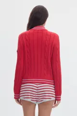 Cardigan de punto color marfil con cierre frontal completo, cuello alto y detalles de rayas en contraste en cuello, puños y ruedo. Presenta diseño de ochos verticales.