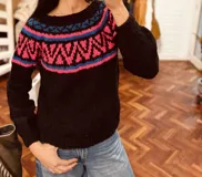 Sweater de mohair negro con diseño geométrico en el canesú en colores rosa y celeste.