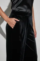 Pantalon de vestir negro de corte recto y tiro alto, confeccionado en tela de terciopelo con acabado brillante.
