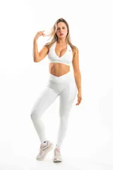 Top deportivo azul con breteles cruzados en la espalda y logo en el frente.