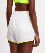 Bermuda deportiva tipo runner color blanco con detalles en bies amarillo flúor, confeccionada en tejido tecnológico con elástico y lazo ajustable en la cintura.