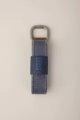 Cinturón gris de tela con hebilla metálica doble cuadrada.