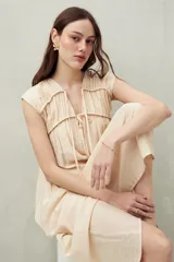 Vestido largo color crema, con escote en V y lazo ajustable.