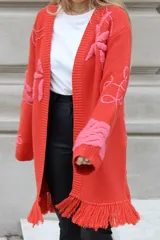 Sacón de algodón color naranja con bordados de motivos tropicales en rosa. Tiene flecos en el ruedo.