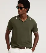Camisa polo Marfinno de tejido de punto en color verde militar, con cuello en V y mangas cortas. Presenta detalles contrastantes en blanco y bordó en el cuello y en los puños.