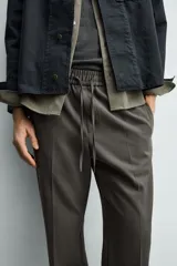 Pantalón regular fit color negro de tejido con viscosa, con cintura elástica ajustable con cordón, bolsillos frontales y traseros.
