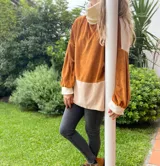 Polerón de corte holgado con mangas largas abullonadas, confeccionado en terciopelo negro con detalles en beige y blanco.