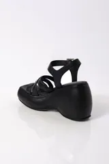 Sandalias negras de plataforma con tiras cruzadas y hebillas con strass.