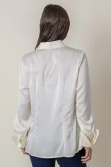 Camisa de satén de seda color marfil, con botones forrados y puños anchos.