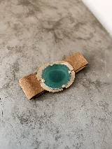 Cinturón artesanal de cuero tostado, con hebilla grande de metal dorado y piedra natural de ágata en tonos verdes.