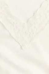 Top de jersey acanalado color blanco off-white, con escote en V profundo adornado con encaje y mangas cortas.