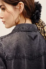 Camisa de denim gris oscuro efecto acid wash, de manga larga, con bolsillos frontales con solapa y broches metálicos a presión.
