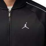 Campera deportiva Nike Jordan color negro, con cierre frontal completo, cuello tipo bomber y detalles de líneas blancas en los hombros. Presenta el logo Jumpman bordado en el pecho.