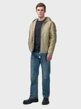 Campera tipo plumífero corto de Moncler, color beige con acabado satinado. Presenta capucha integrada, cierre frontal con cremallera, bolsillos laterales y un bolsillo con solapa en la manga izquierda que incluye el logo de la marca.