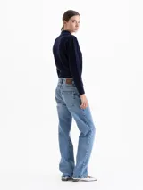 Pantalón de jean recto de tiro medio en color azul lavado. Presenta un diseño clásico de cinco bolsillos, con cierre frontal y botón metálico.